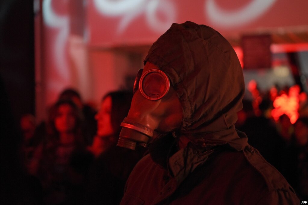 Një burrë i veshur me maskë mbrojtëse gazi shihet në një prej festimeve në Natën e Shtrigave në Prishtinë, 31 tetor 2022.