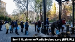 У Києві після одного з російських обстрілів у кількох районах міста зникло водопостачання. Люди біля одного з бюветів у центральній частині міста набирають воду