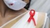 INDIA HEALTH WORLD AIDS DAY -- A voulnteer wears a red AIDS ribbon badge during an awareness rally on World AIDS Day, organized by the Durbar Mahila Samanwaya Committee in the Sonagachi red light district, in Kolkata, India 01 December 2020