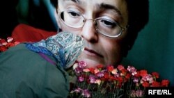 A woman lays flowers at the apartment building where journalist Anna Politkovskaya was slain in October 2006. (file photo)