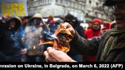 Un protestatar rus își arde pașaportul în timpul unui miting împotriva invaziei militare a Rusiei în Ucraina. Belgrad, Serbia, 6 martie 2022