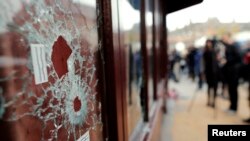 След от пуль в окне ресторана на месте теракта в Париже. 14 ноября 2015 года. 