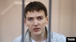 Ukrainian military pilot Nadia Savchenko stands inside a defendants' cage as she attends a court hearing in Moscow in May.