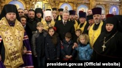 Посередині: глава єдиної Православної церкви України (ПЦУ) митрополит Київський Епіфаній і президент України Петро Порошенко у Храмі Різдва Пресвятої Богородиці у Дніпрі, 17 грудня 2018 року