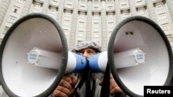 Участник акции в поддержку евроинтеграции Украины стоит у здания правительства страны. Киев, 25 ноября 2013 года.