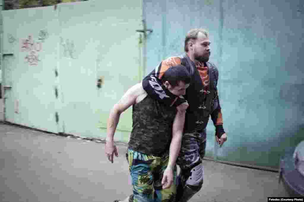 An activist detains an &quot;illegal,&quot; trying to escape through a window after a raid by the &quot;Shield of Moscow&quot; movement.&nbsp;Together with police, activists check the residences of migrants. Moscow, 2013. Photo by Constantine Salomatin.