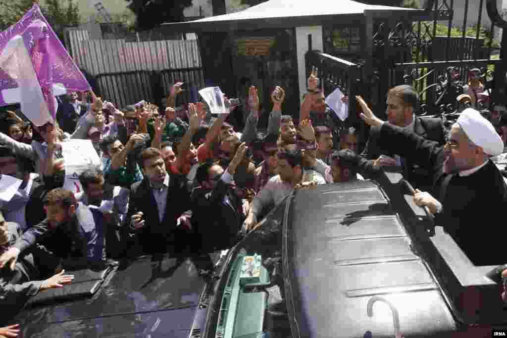 Iranian President Hassan Rohani waves to supporters as his motorcade leaves Tehran's Mehrabad Airport after his arrival from New York on September 28, 2013. Rohani had a historic phone conversation with U.S. President Barack Obama while he was in the United States. (IRNA)