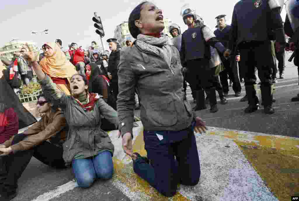 Demonstrators protest near police on January 25, 2011, to demand the ouster of Mubarak and call for reforms.