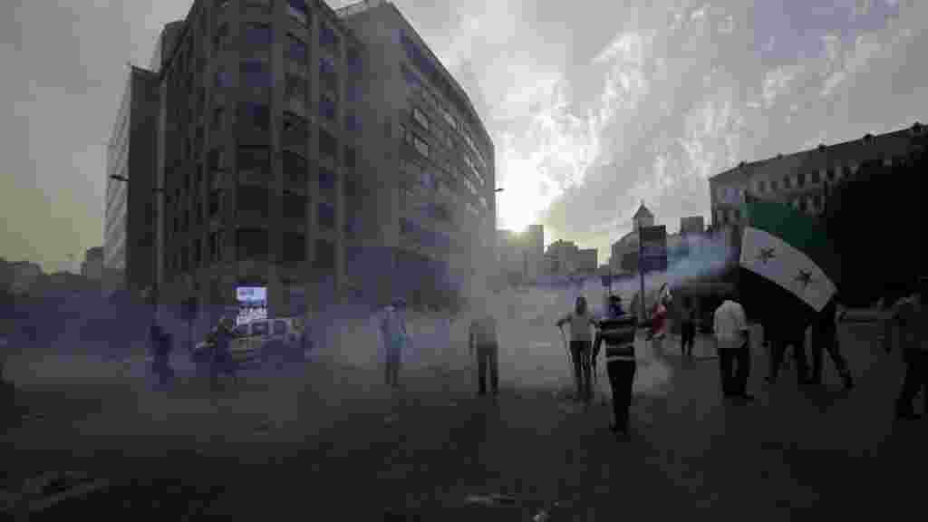 OCTOBER 21, 2012 -- Demonstrators ignore clouds of tear gas fired by police as they storm the governmental palace in Beirut following the funeral of top intelligence chief General Wissam al-Hassam, who was killed by a car bomb on October 19. (AFP/Joseph Eid) 