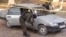 Kazakh police investigators examine a car at the site of an attack in Taraz that left eight people dead