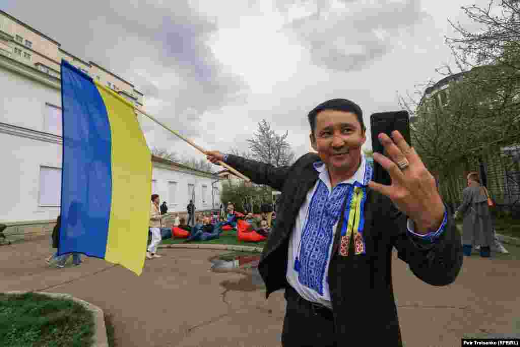 A man poses for a selfie with the Ukrainian flag.