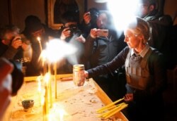 Gyertyát gyújt az áldozatok emlékére Ursula von der Leyen, az Európai Bizottság elnöke egy templomban az ukrajnai Bucsában talált tömegsír közelében 2022. április 8-án