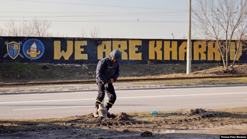 Украинский сапер удаляет часть российской ракеты, упавшей на улицу в Харькове
