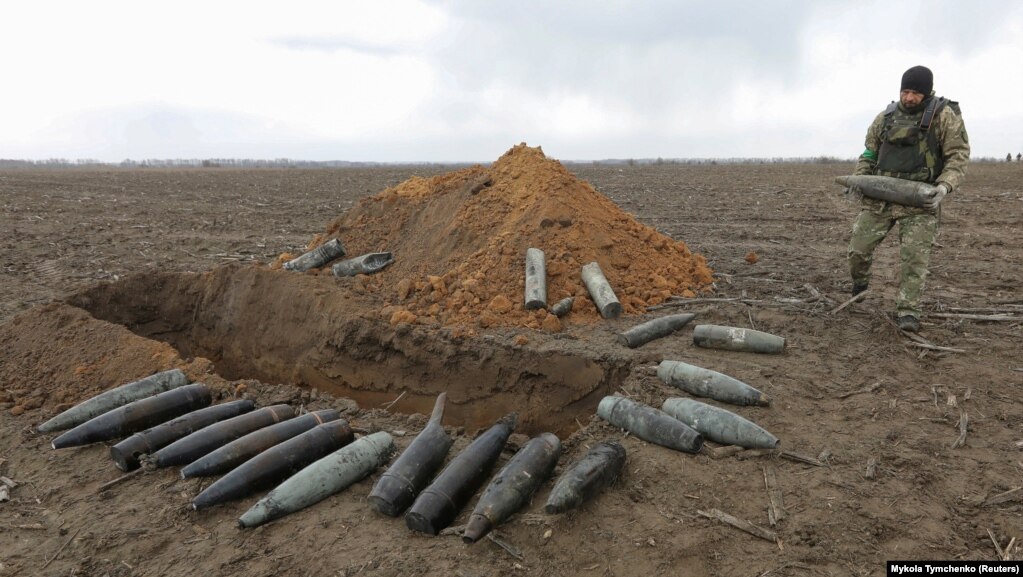 Një ushtar mban njërën prej disa predhave të pashpërthyera pranë Motizhinit, më 10 prill.&nbsp;Agjencia e Emergjencave e Ukrainës ka paralajmëruar civilët për "shumë" eksplozivë - potencialisht vdekjeprurës - që fshihen në zonat e çliruara së voni nga pushtimi rus.