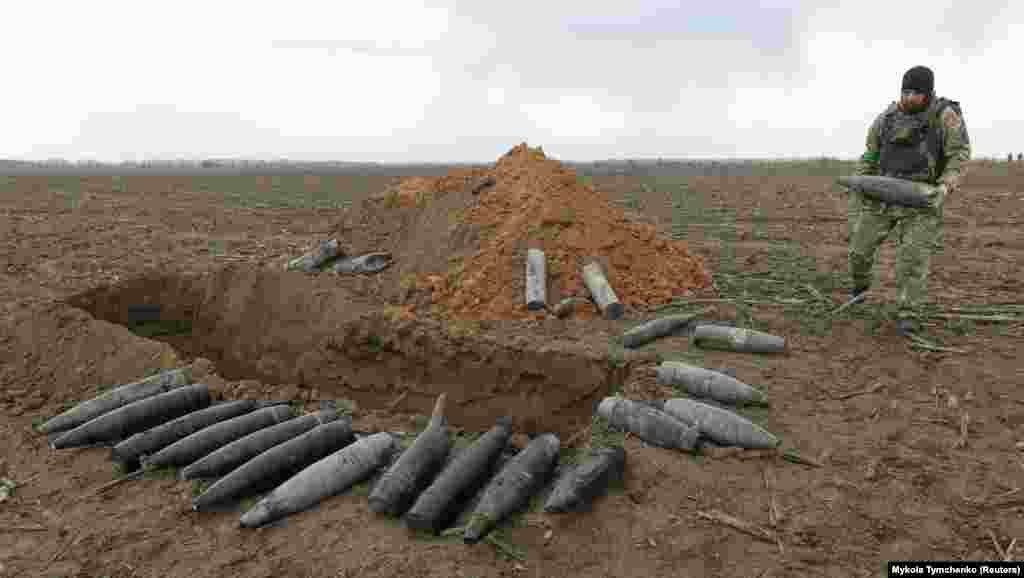 A sapper carries one of several unexploded shells discovered near&nbsp;Motyzhyn on April 10. Ukraine&#39;s state emergency agency has warned civilians of &quot;many&quot; potentially lethal explosives that lurk in areas recently freed from Russian occupation.&nbsp;