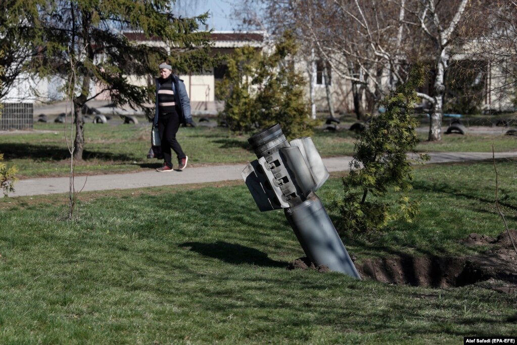 Një grua duke kaluar pranë bishtit të një rakete Smerch në rajonin e Harkivit, më 7 prill. Disa nga raketat e përdorura nga forcat ruse u ndanë në dy pjesë gjatë fluturimit.