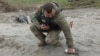 Украинский сапёр осматривает неразорвавшуюся часть кассетной бомбы