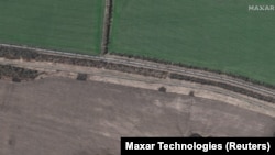 A satellite image shows armored vehicles and trucks of a Russian military convoy moving south through the town of Velykyi Burluk in eastern Ukraine on April 8. Maxar Technologies said the convoy consisted of hundreds of vehicles and extended for at least 13 kilometers.