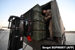 Ukrainian soldiers unload U.S. made Stinger missiles and the other military assistance shipped from Lithuania to Boryspil Airport in Kyiv before the Russian invasion.