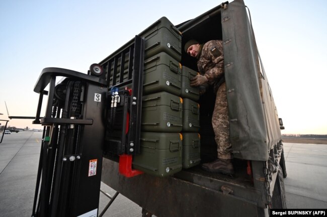 Ukrainian soldiers unload U.S. made Stinger missiles and the other military assistance shipped from Lithuania to Boryspil Airport in Kyiv before the Russian invasion.