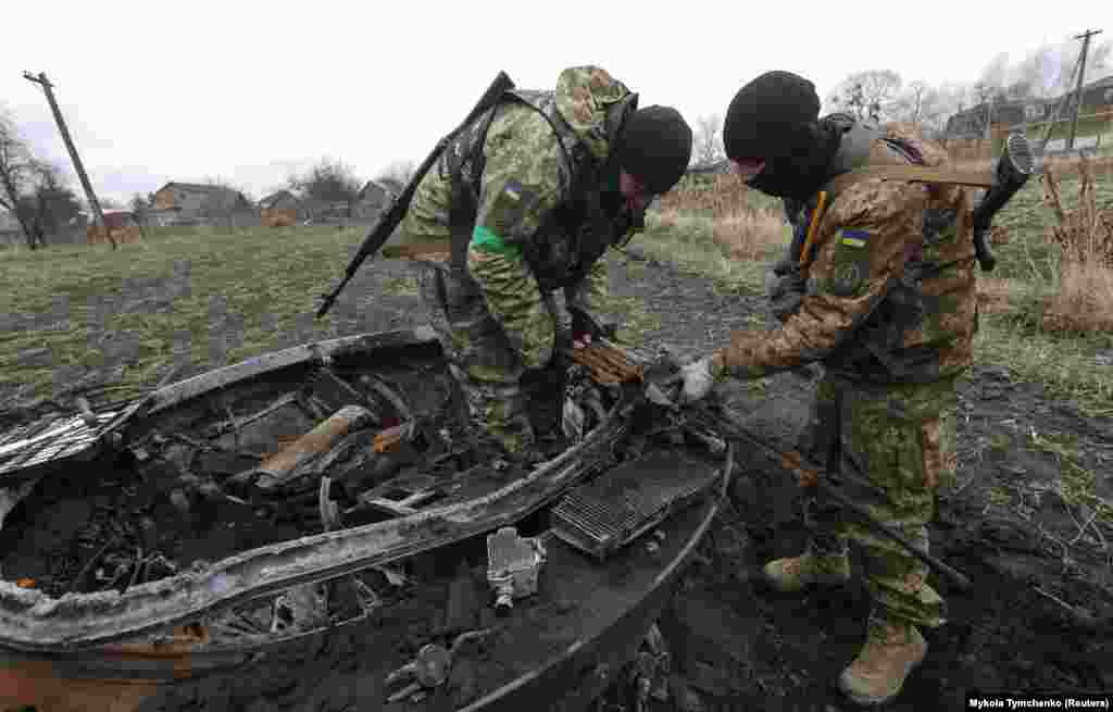 Sappers work to remove a machine gun from the shell of a Russian tank near Motyzhyn on April 10.&nbsp;