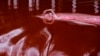 Олимпийская чемпионка и чемпион мира Рута Мейлютите переплывает пруд, окрашенный в красный цвет в знак осуждения кровопролития. Фото сделано у Посольства России в Вильнюсе, Литва.