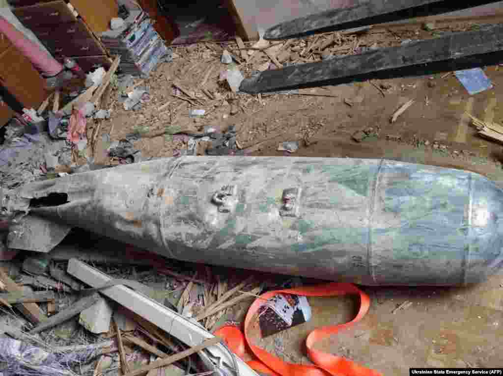 An unguided bomb, flattened by impact, pictured in an apartment in the northern city of Chernihiv. A video of Ukrainian bomb disposal experts at work shows them pouring water over the nose of a bomb similar to the one seen here before carefully unscrewing the detonation fuse and carrying it away.&nbsp;
