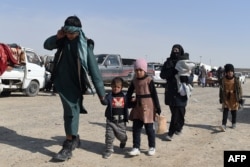 An Afghan migrant family prepares to leave Iran and cross over into Zaranj, capital of the southwestern Afghan province of Nimroz.