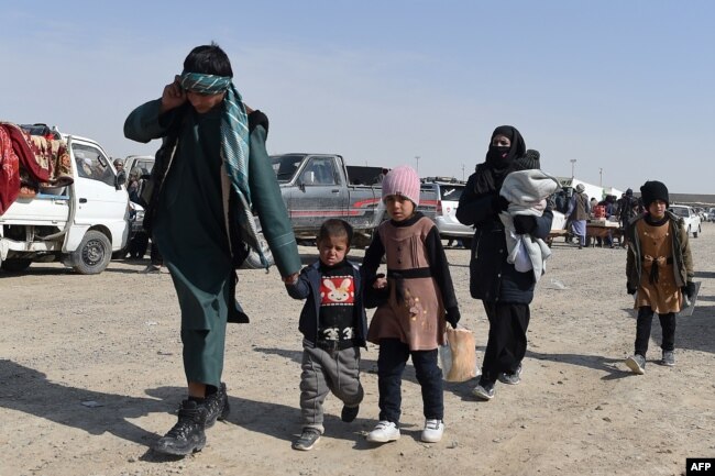 An Afghan migrant family prepares to leave Iran and cross over into Zaranj, capital of the southwestern Afghan province of Nimroz.