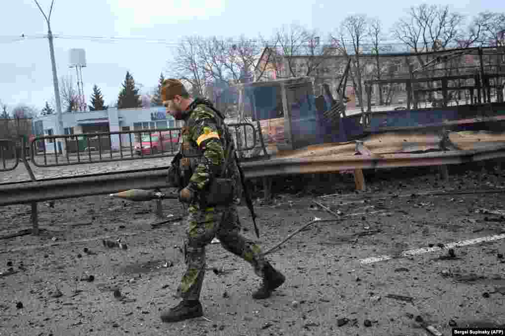 A Ukrainian serviceman carries a rocket-propelled grenade left behind after a battle in Kyiv on February 26.&nbsp;