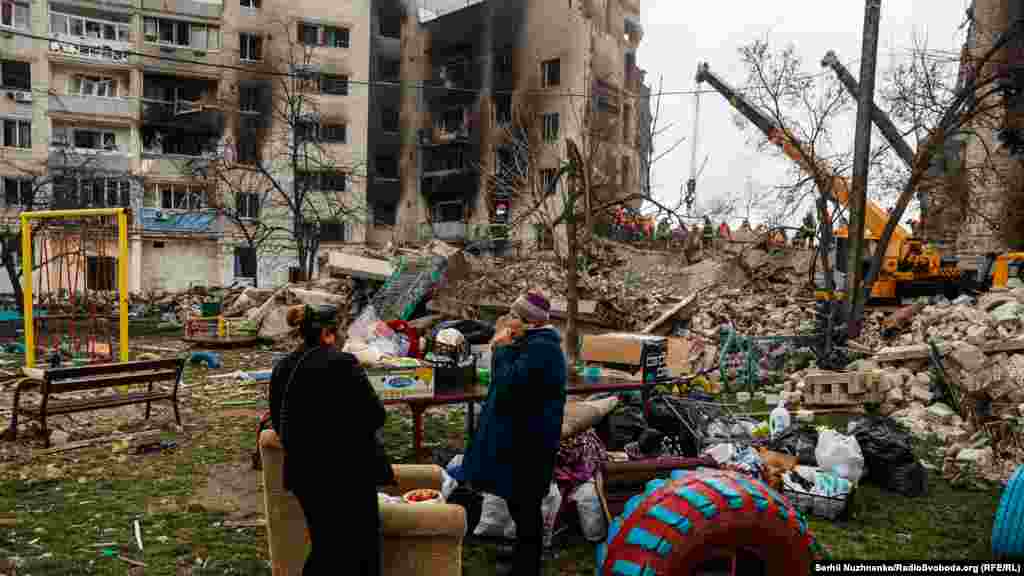 Місцеві жителі харчуються біля свого будинку в Бородянці, зруйнованого російськими авіаударами&nbsp;