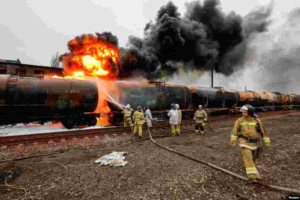 Tűzoltók küzdenek a lángokkal egy tüzérségi támadást követően a sahtarszki vasúti csomópontnál