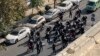 Iranian police arrive to disperse a protest in Tehran.

