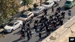 Iranian police arrive to disperse a protest in Tehran.
