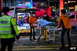 Medicii din Seul transportă o victimă la spital după busculadă produsă la petrecerea de Halloween. Photo by Jung Yeon-je / AFP)