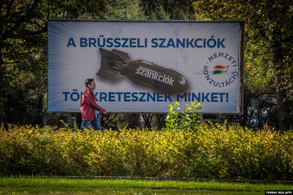 Мужчина проходит мимо рекламного щита в столице Венгрии Будапеште, на котором написано: &laquo;Брюссельские санкции наказывают нас&raquo; против России за ее неспровоцированное вторжение в Украину.