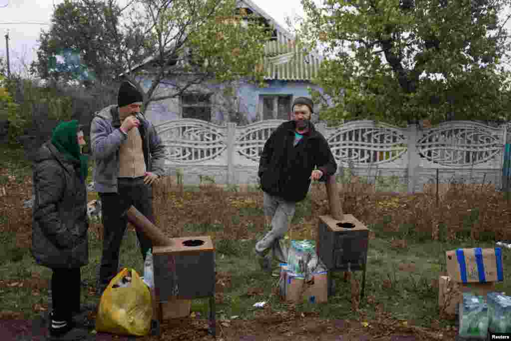 Жители села в Николаевской области с печками, водой и продуктами, доставленными волонтерами. Печи можно использовать для приготовления пищи, но люди, с которыми беседовали корреспонденты Reuters, сказали, что будут отапливать подвалы. Один местный житель сказал Reuters: &laquo;Мы прячемся от обстрелов в подвале. И нам нужна эта печь, чтобы согреться зимой&raquo;