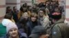 Люди, прибывшие из оккупированного РФ Херсона, ждут дальнейшего перемещения вглубь России внутри Джанкойского железнодорожного вокзала в Крыму, 21 октября 2022 года