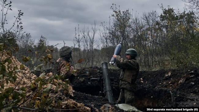 Vojnik ubacuje granatu kalibra 120 mm u minobacač, istočna ukrajinska regija Donbas, oktobar 2022.