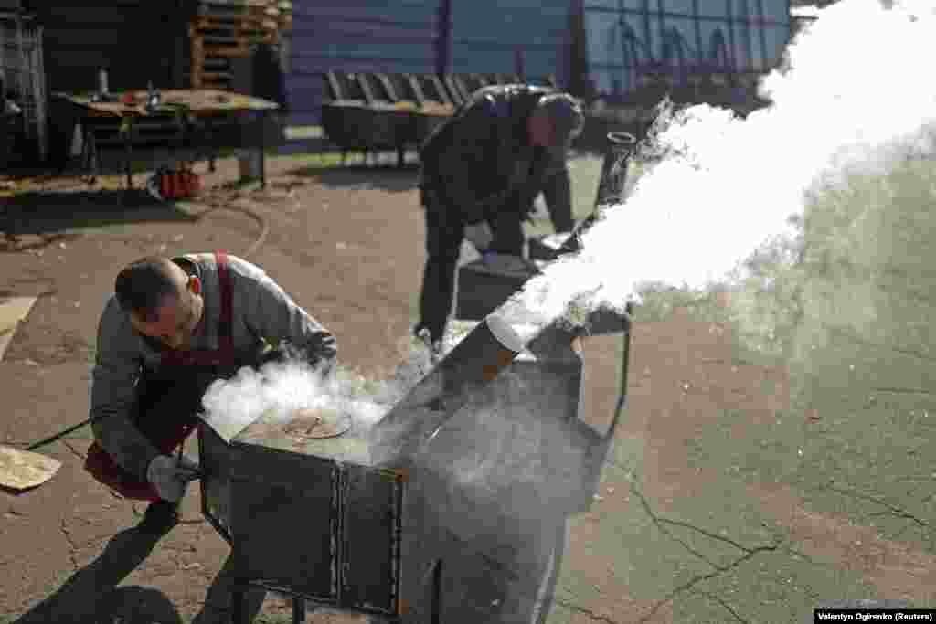 Volunteer workers test out a newly made stove in Ukraine&#39;s Mykolayiv region on October 24.&nbsp;