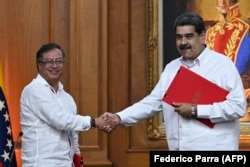 Президент Колумбии Густаво Петро (слева) и президент Венесуэлы Николас Мадуро обмениваются рукопожатием после подписания соглашений о восстановлении дипломатических отношений между двумя странами, ранее разорванных на 3 года. Президентский дворец Мирафлорес в Каракасе, 1 ноября 2022 года