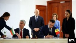 Българският и молдовският президент Румен Радев и Мая Санду (отзад) на подписването на договора в Кишинев, 27 октомври.
