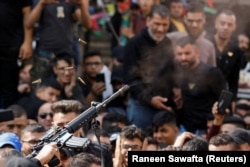 Naoružani muškarac puca iz oružja u zrak dok ožalošćeni prisustvuju sahrani člana palestinske grupe 'Lavlja jazbina' koji je ubijen tokom sukoba s izraelskim snagama, u Nablusu na Zapadnoj obali pod izraelskom okupacijom, 25. oktobra 2022.