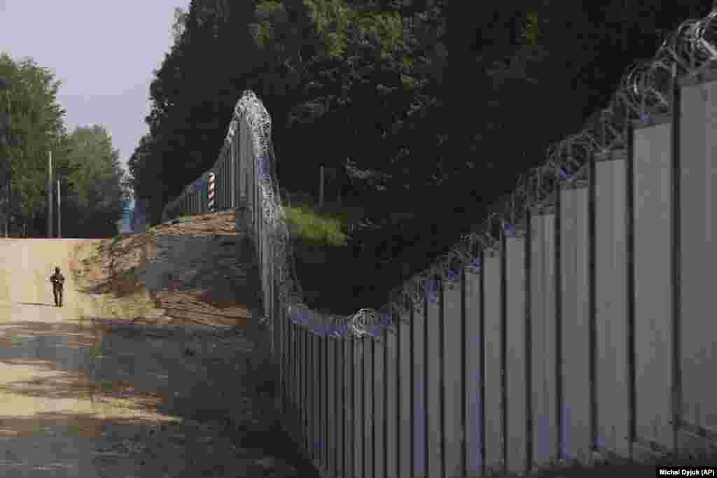 A Polish border guard patrols alongside a massive new barrier that was built on the country&rsquo;s border with Belarus. This fence was completed in June after Middle Eastern migrants were allegedly &quot;funneled&quot; through Belarus and toward its borders with the EU, apparently as a way to pressure Brussels over sanctions. &nbsp;