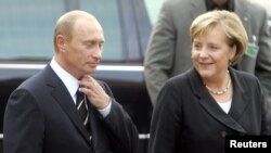 Cancelarul german, Angela Merkel, alături de președintele Federației Ruse, Vladimir Putin, la conferința de la Dresda din octombrie 2006. Dresda a fost orașul unde a lucrat Vladimir Putin ca ofițer KGB înainte de căderea Zidului Berlinului. Vladimir Putin știe germană, iar Angela Merkel știe rusește, născută fiind în fosta RDG.