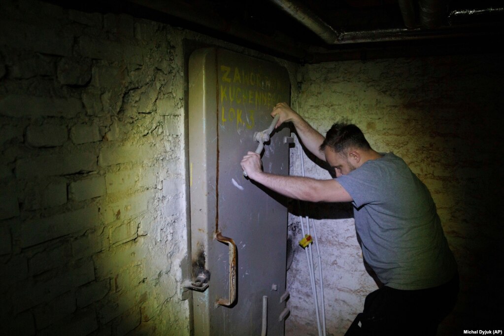 Jacek, 37 vjeç, duke mbyllur derën e një strehimoreje në bodrumin e një ndërtese banimi në Varshavë, Poloni, më 19 tetor. Mes luftimeve në zonat përreth instalimeve të energjisë bërthamore të Ukrainës dhe kërcënimeve të nënkuptuara të Rusisë për përdorimin e armëve bërthamore, Polonia ka urdhëruar pasjisjen me inventar të strehimoreve të saj.