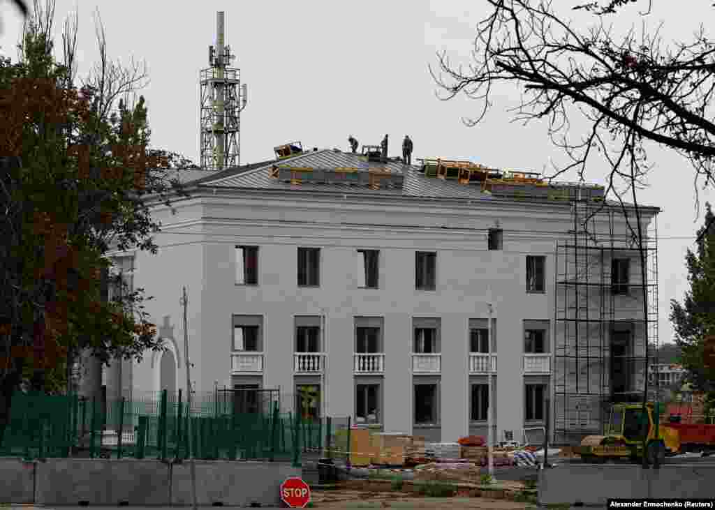 An August 21 photo of the rebuilding of the Mariupol Chamber Philharmonic building.&nbsp; Reconstruction work began almost immediately after the Russian takeover on some buildings in the center of Mariupol, but the images in this gallery that were released by Reuters on October 30 appear to show that vast swathes of the city remain uninhabitable.&nbsp;
