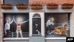 Снимка, направена на 5 септември 2022 година, демонстрира графит в центъра на Белфаст на художника Киарън Галахър. Той изобразява като боксьори Лиз Тръс, която печели пред Риши Сунак, до Борис Джонсън и английския министър по Брекзит Джейкъб Рийс-Мог. 