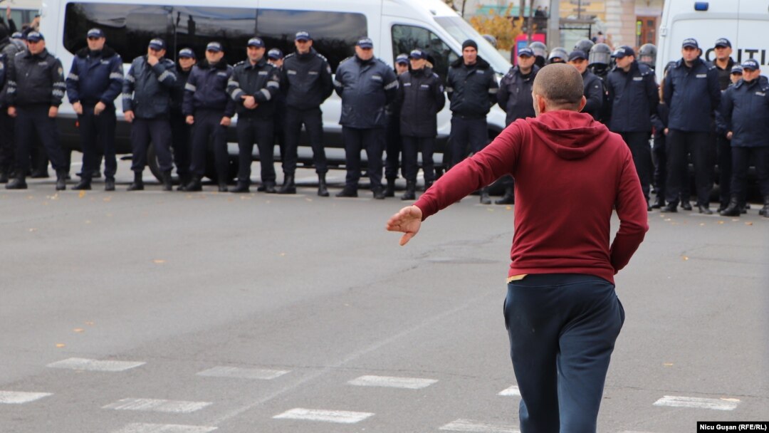 Un participant la protestul Partidului Șor din 23 octombrie se îndreaptă către PMAN. Câteva momente mai târziu acesta este reținut de polițiști pentru forțarea cordonului forțelor de ordine