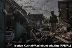Українські військові дістають тіла загиблих цивільних у Яковлівці внаслідок удару російської армії